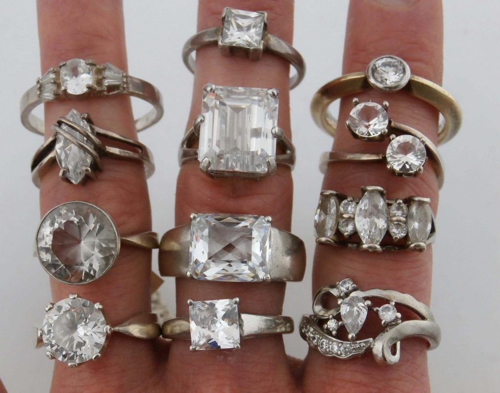 11 srebrnych pierścionków z cyrkonią na dłoni
