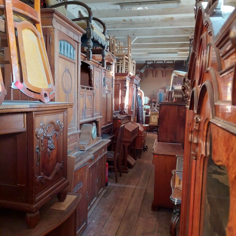 Antyczne meble w Magazynie Wystawowym Dessa Antyki Olsztyn: biurko, krzesło, kredens dębowy, fotel