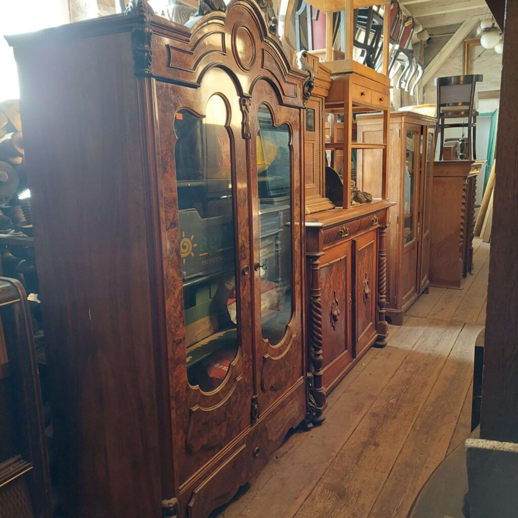 Antyczne meble w Magazynie Wystawowym Dessa Antyki Olsztyn: witryna ludwikowska, komoda, stolik