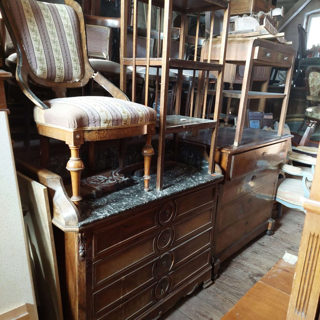 Antyczne meble w Magazynie Wystawowym Dessa Antyki Olsztyn: toaletka, komoda, krzesło, etażerka, stolik por radio