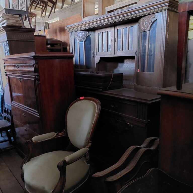 Antyczne meble w Magazynie Wystawowym Dessa Antyki Olsztyn: stary kredens, sekretera, fotel